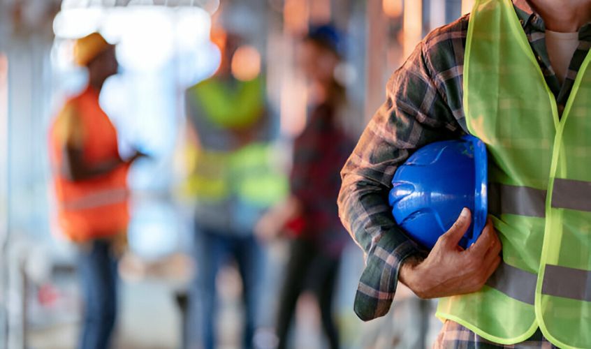 Foto de portada utilizada para el blog - seguridad en la construcción donde se ve un trabajador sujetando su casco